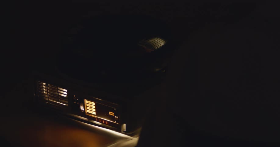Close up of light coming out of a carousel slide projector inside a dark room