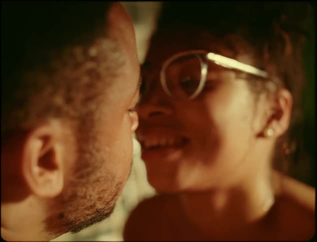 A man and woman kiss in the tub