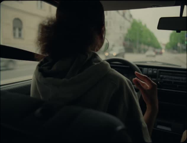 Young angry woman argues and gestures while driving a car on the city streets