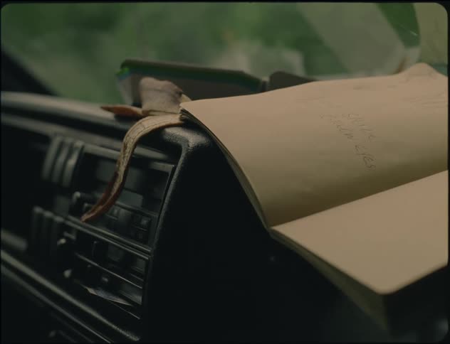 An open journal is placed on a parked car