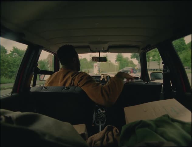 A man backing up a car and then driving forward
