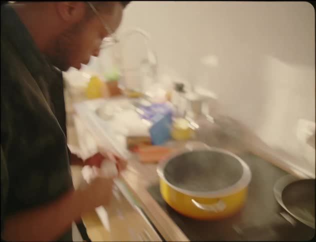 Young man in kitchen cooking chopping vegetables and doing doing various food prep