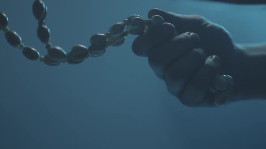 A person is holding a beaded necklace