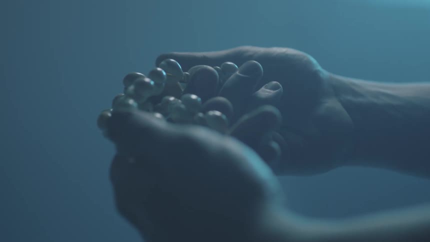 A person wraps a necklace in their hands