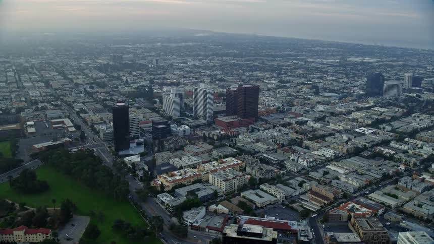 Aerial footage of sunrise flying over Interstate 405 and apartment buildings following Wilshire Boulevard in Sawtelle California