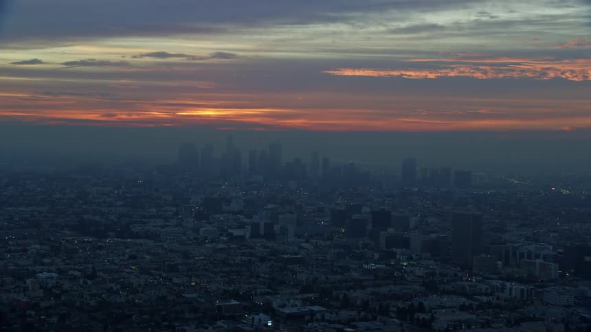 Aerial footage captures a hazy morning view of Downtown Los Angeles skyscrapers in winter