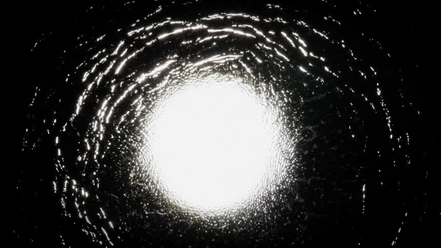 Particles move out of a white rippling vortex in the darkness