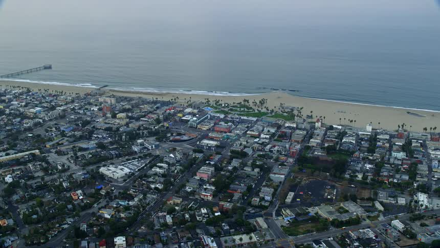 A stunning aerial footage of Venice Beach and Windward Plaza at sunrise in Californias Venice offering a mesmerizing view of the seaside shoreline and residential area
