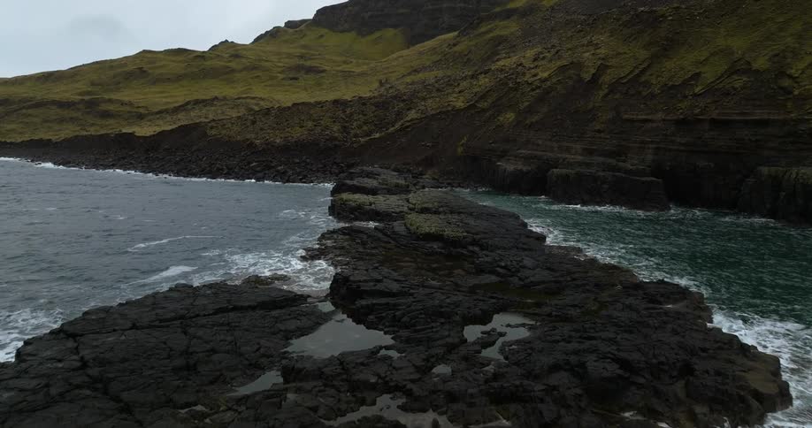 Waves crash onto rock outcroppings leading to cliff
