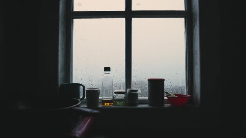 Bottles and cups on the windowsill while raining
