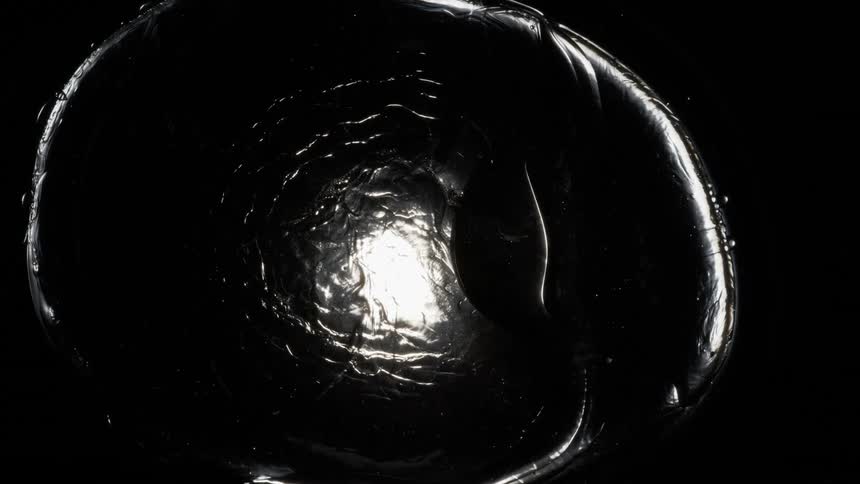 Particles move out of a white rippling vortex in the darkness