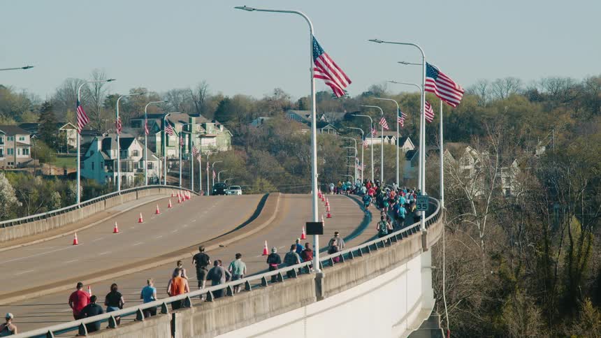 A group of men jogging on a highway the men are dressed in workout clothes and appear to be in good physical shape