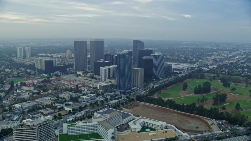 Aerial footage captures a picturesque sunrise over Century City in California with views of towering skyscrapers and a lush golf course