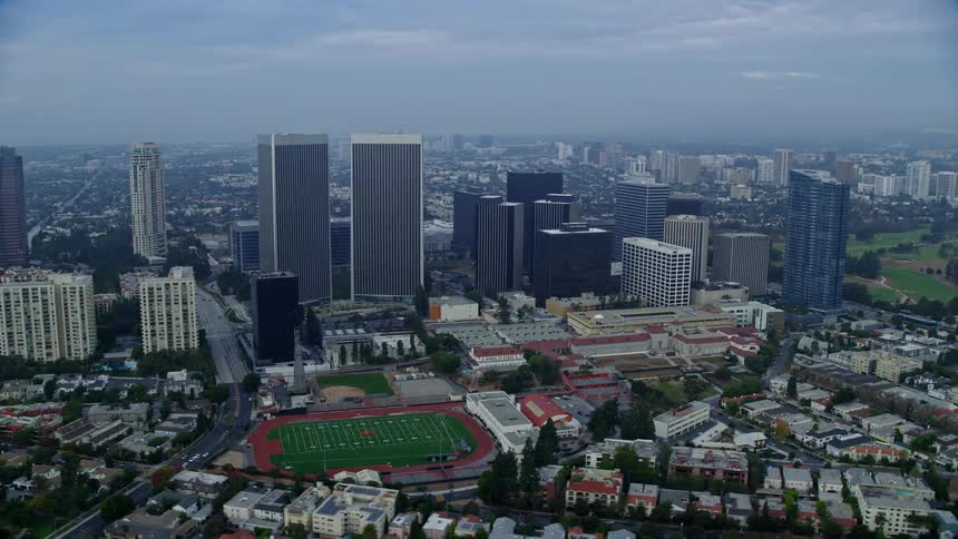 A stunning aerial footage captures condominiums and skyscrapers near Beverly Hills High School during sunrise in Century City California
