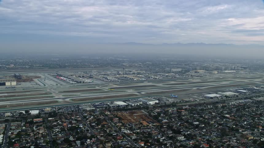An epic aerial footage of a sideview of LAX on a cloudy morning during sunrise in Los Angeles California