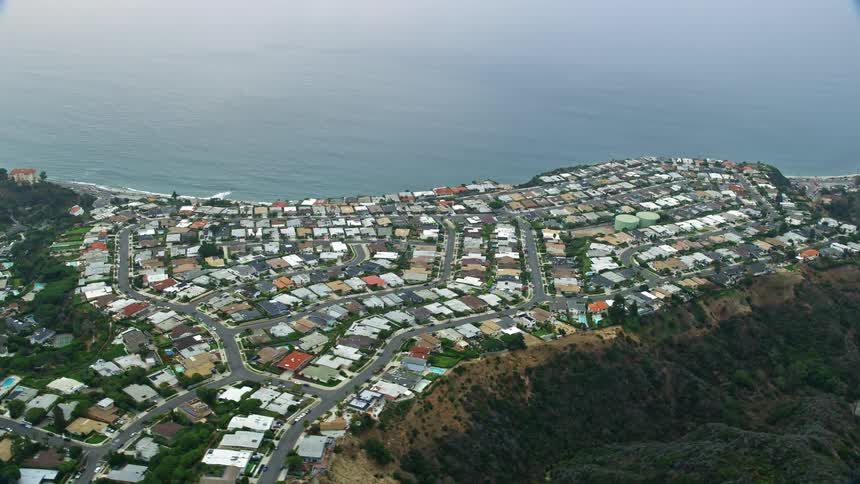 Aerial footage of oceanfront homes in Pacific Palisades California shot during the morning hours