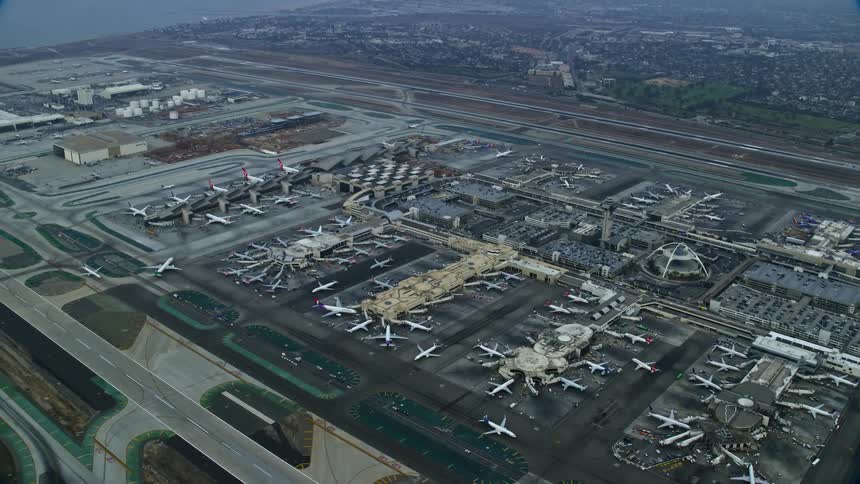 An epic shot of flying over LAX and parked airplanes at sunrise in Los Angeles California