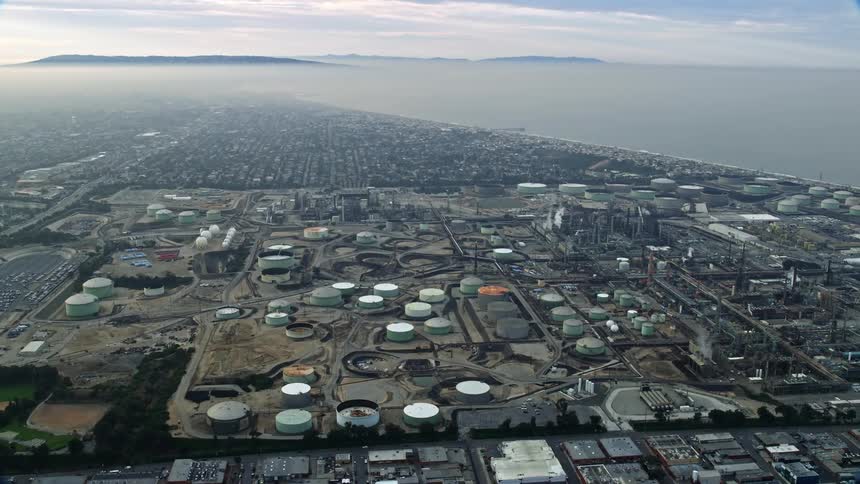 Aerial footage of oil refineries seen on a cloudy day in El Segundo California with a waterfront industrial view