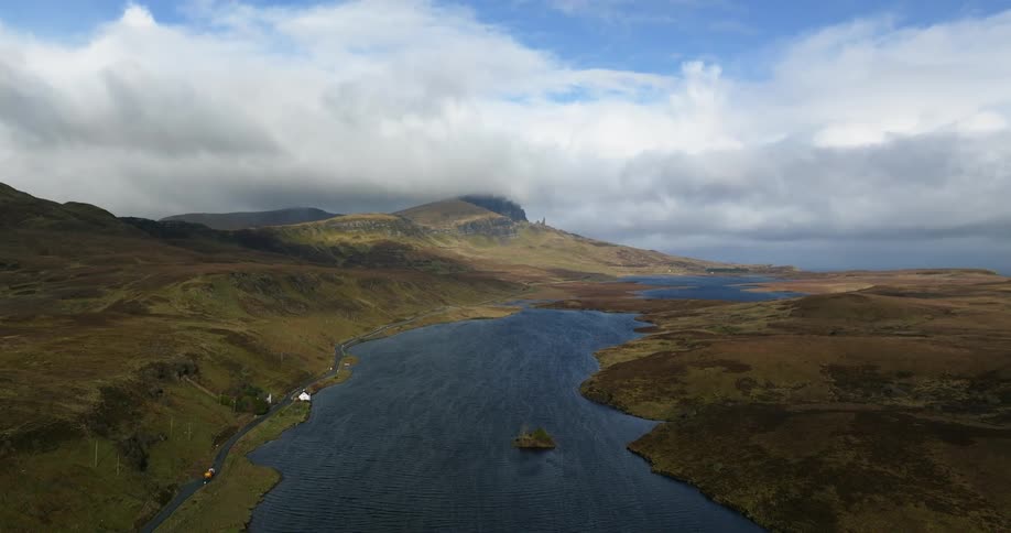 An aerial view of a river running through a hilly landscape in nature