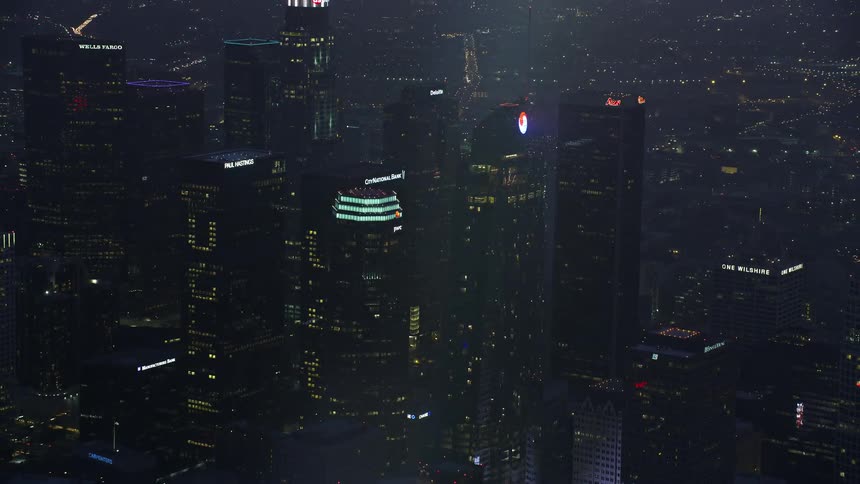 A stunning aerial view at sunrise showcases Downtown LAs renowned Wilshire Grand Center amidst towering skyscrapers and a cloudy winter sky in California