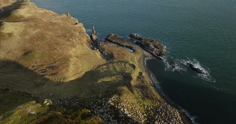Aerial view of a small house atop a mountain in front of the coast at daytime