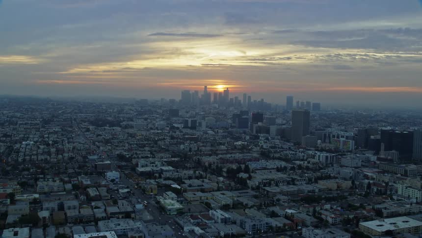 Aerial view of Koreatown office buildings and the Downtown Los Angeles skyline at sunrise during winter