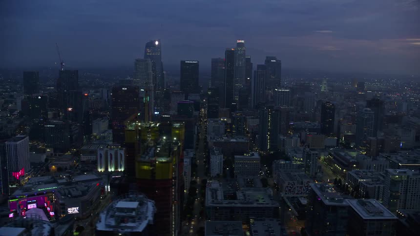 A breathtaking aerial view of Downtown LAs tall skyscrapers during sunrise on a cloudy winter morning in California