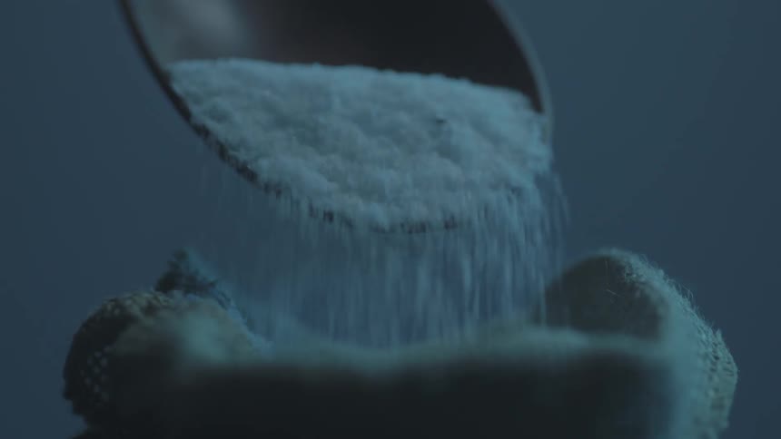 A person scoops up powder in a spoon