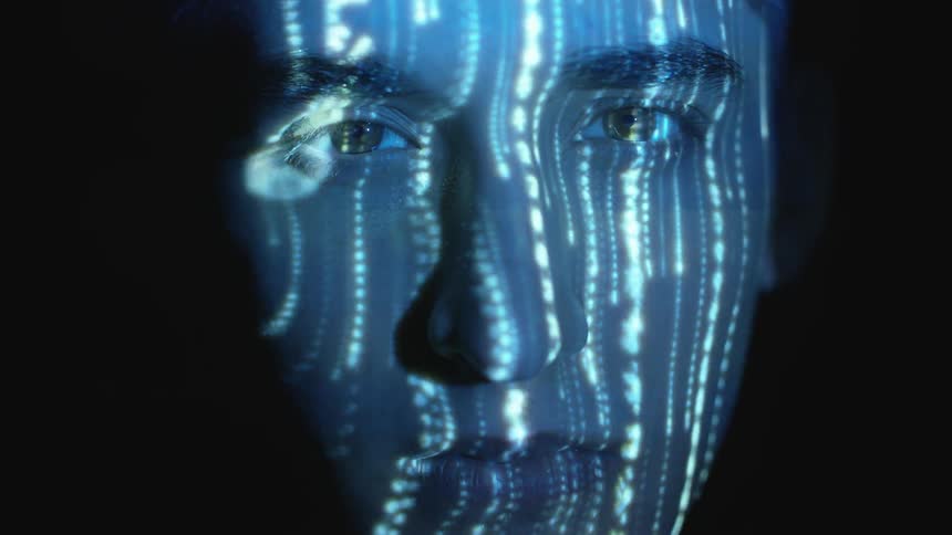 Lines of letters and numbers shine on a person's face