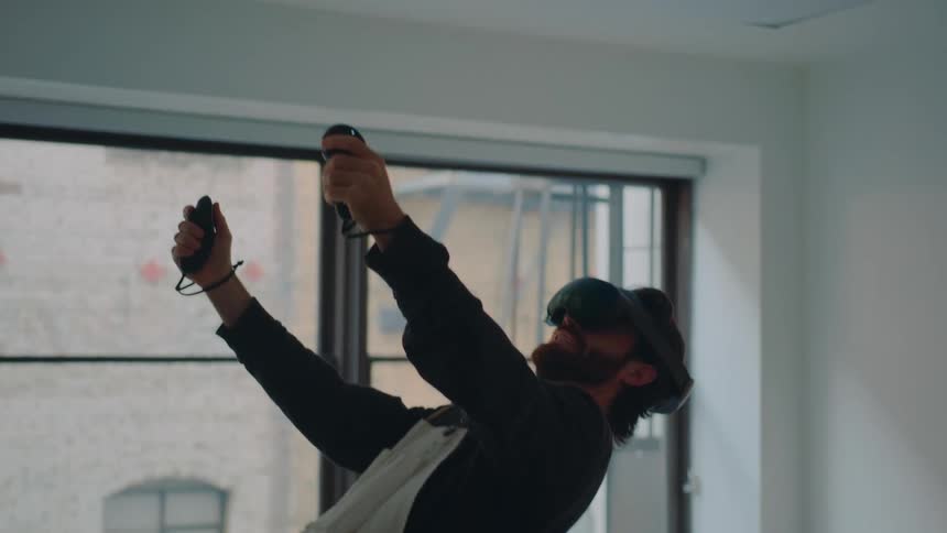 A man holds his arms up while playing a virtual reality game