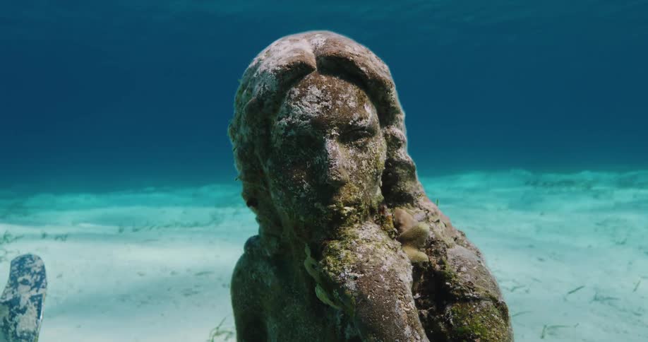 Close up view of a statue on the ocean floor is displayed