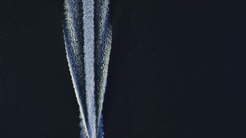 A birds eye view of a boat speeding across water