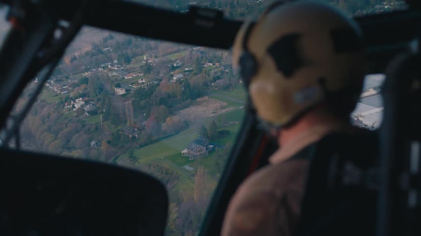 A man is flying a helicopter over a town