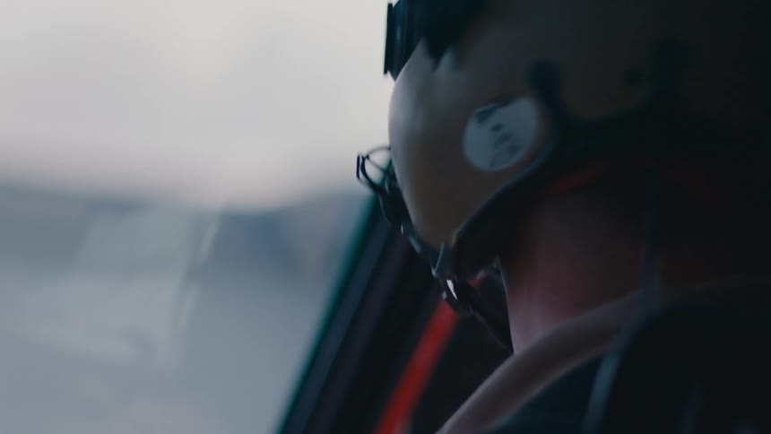Pilot with flight helmet flies helicopter