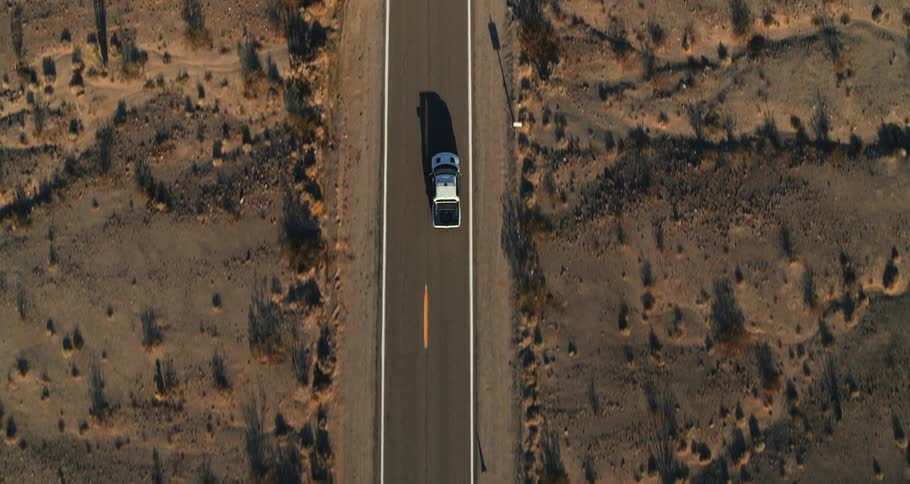 A person is driving their car through the desert