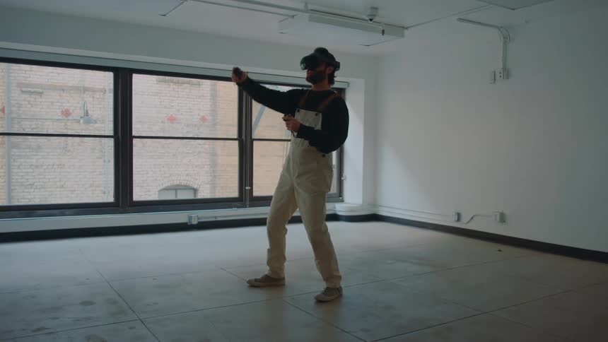 Man standing in empty room plays using vr goggles