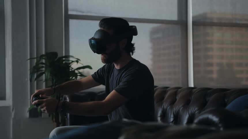 A man plays a virtual reality game on the couch