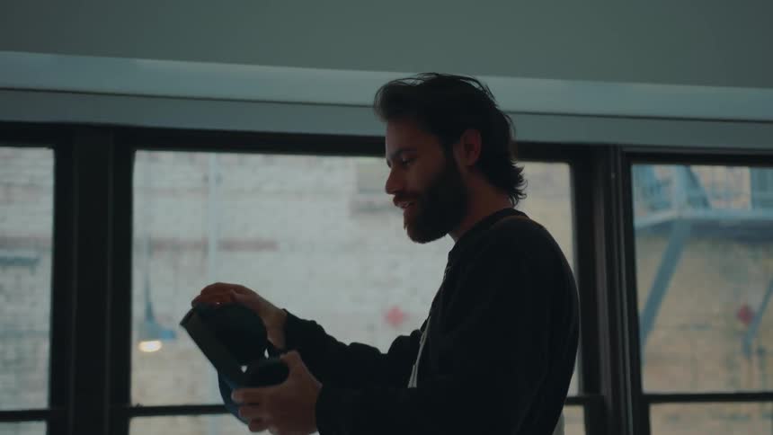 A man takes off his virtual reality headset and runs his hand through his hair