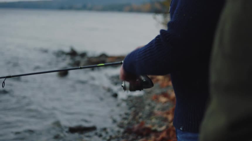 A man is reeling his fishing pole