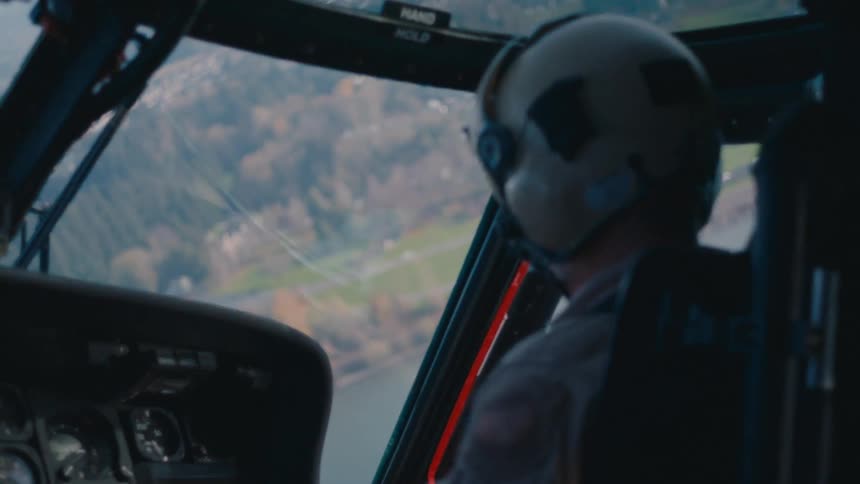 A man flies a helicopter over a neighborhood