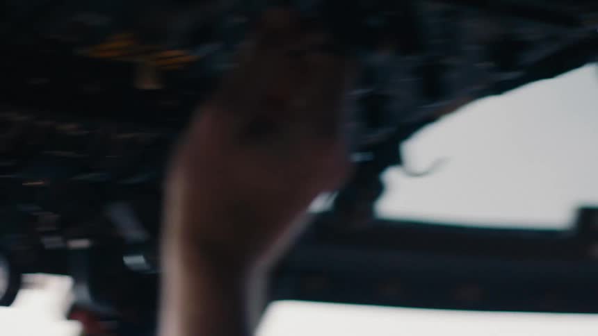 A person presses buttons in the cockpit