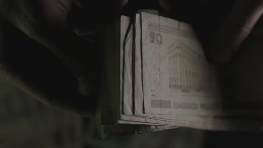 A person flips through paper money