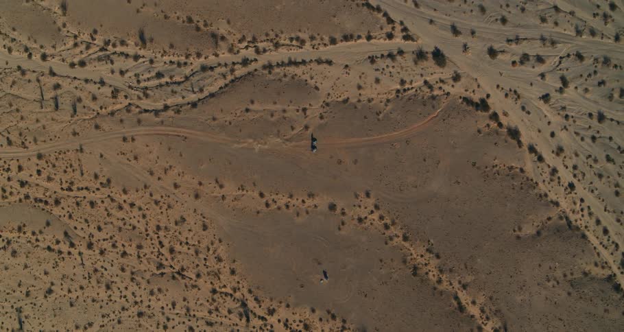 Birds eye view of cars driving through the desert