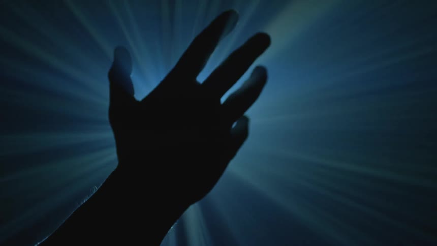 A hand is blocking the light of a projector