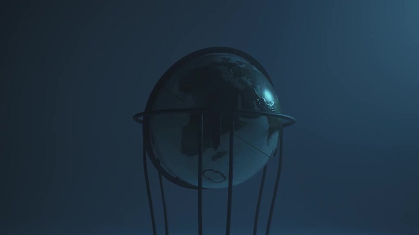 A world globe sits in a dark room