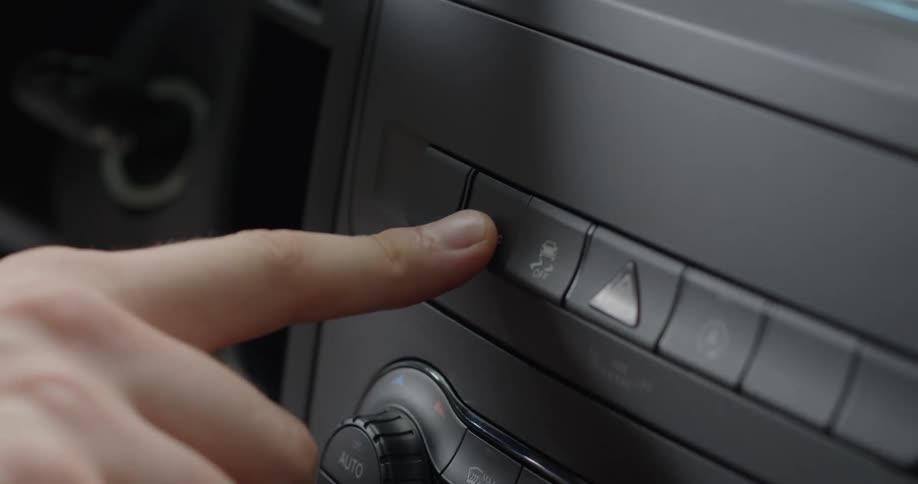 A person presses a button on the dashboard