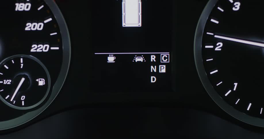 A close up of a car dashboard with gauges and speedometers