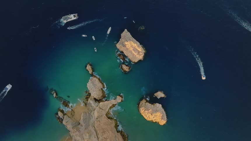 Boats are driving around the island in the ocean