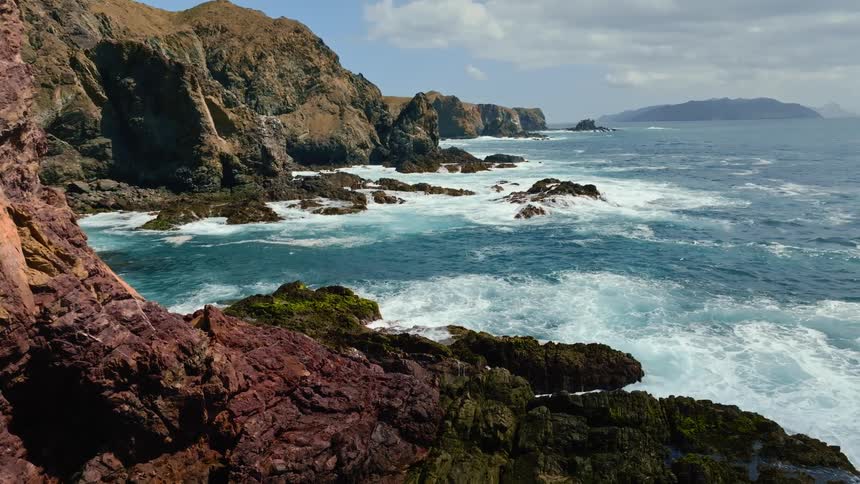 Aerial view of mountains near the ocean is displayed