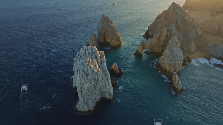 Boats are driving around the ocean at dusk